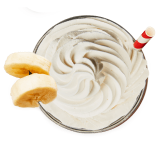 Bananas & Cream protein shake in a glass with straw